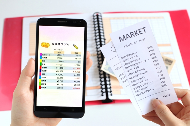 家計簿アプリとレシートを照らし合わせ、日用品の出費を可視化して無駄遣いを防ぐ節約術のイメージ。