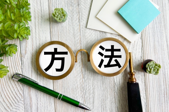 自分に合ったVポイントの貯め方や方法を見つけるためのヒント。木目調のデスクに置かれた「方法」の文字と文房具。